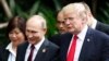 U.S. President Donald Trump, right, and Russia's President Vladimir Putin, center, talk during a group photo session at the APEC Summit in Danang, Vietnam, Nov. 11, 2017.
