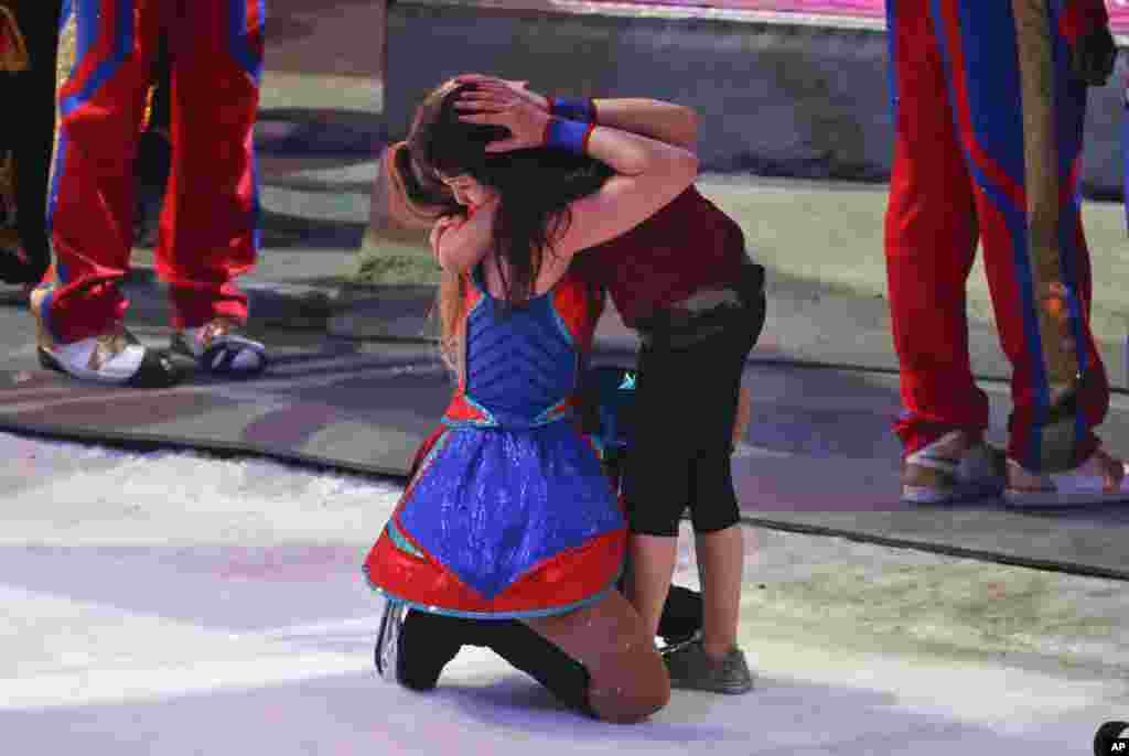 A performer hugs a young girl on the show floor after the final performance of the Ringling Bros. and Barnum & Bailey Circus in Uniondale, New York, May 21, 2017.