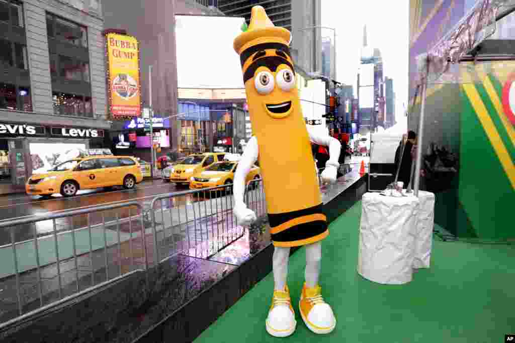 A dandelion crayon character poses for photos during a Crayola event in New York's Times Square. Crayola announced Friday, National Crayon Day, that it's replacing the color dandelion in its 24-pack with a crayon in "the blue family."