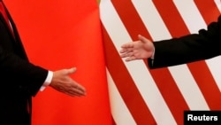 资料照:美国总统特朗普和中国国家主席习近平在北京人民大会堂发表联合声明后握手。(2017年11月9日)