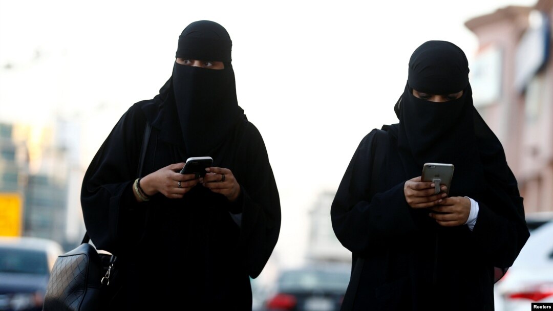 FILE - Saudi women use the Careem app on their mobile phones in Riyadh, Saudi Arabia, Jan. 2, 2017.Saudi Arabia is well known as the world's most gender-segregated nation, where women live under the supervision of a male guardian, cannot drive, and in public must wear head-to-toe black garments.