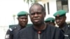 Bayelsa State Governor Diepreye Alamieyeseigha, centre, stands outside his house guarded by policemen in Yenagoa, Nigeria, in this file photo dated November 27, 2005.