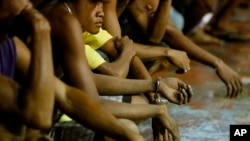 FILE - Rounded up residents, mostly males, wait to be transported to a police station in President Rodrigo Duterte's "War on Drugs" campaign, in the slum community of Tondo, in Manila, Philippines, Sept. 30, 2016. More than 3,600 drug users and dealers reportedly have been killed in the Philippines since Duterte took office. His critics say concerns over being held accountable for the deaths are pushing Duterte to withdraw from the ICC.
