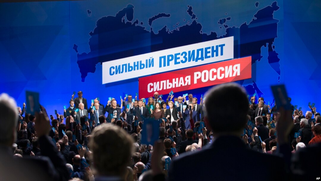 Supporters of incumbent Vladimir Putin vote to officially nominate him for presidency in Moscow, Russia, Tuesday, Dec. 26, 2017. Putin is set to easily win a fourth term in office in the March 18 election, with his approval ratings topping 80 percent.