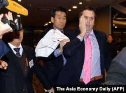 美国驻韩国大使李柏特(右)用手按住脸部刀伤离开世宗文化会馆