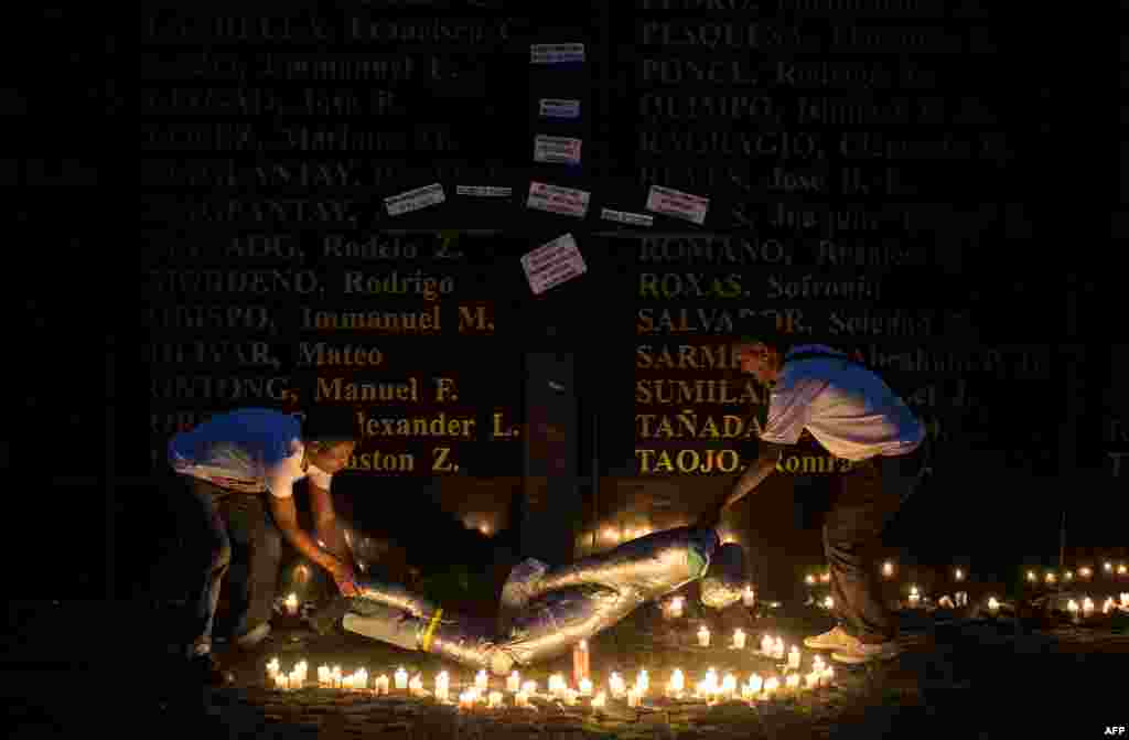 People lift a mock victim during a vigil in support of the families of victims of extra-judicial killings in Manila, Philippines. More than 6,000 people have died, seven months after President Rodrigo Duterte ordered an unprecedented war on drugs, which has drawn global criticism, but enjoys popularity in the mainly Catholic nation.