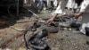 A man collects parts of a damaged bus hit by a remote control bomb on outskirts of Kabul, Afghanistan, August 7, 2012.