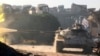 FILE - A Free Syrian Army tank fires in Ramousah area, southwest of Aleppo, Syria, Aug. 2, 2016.