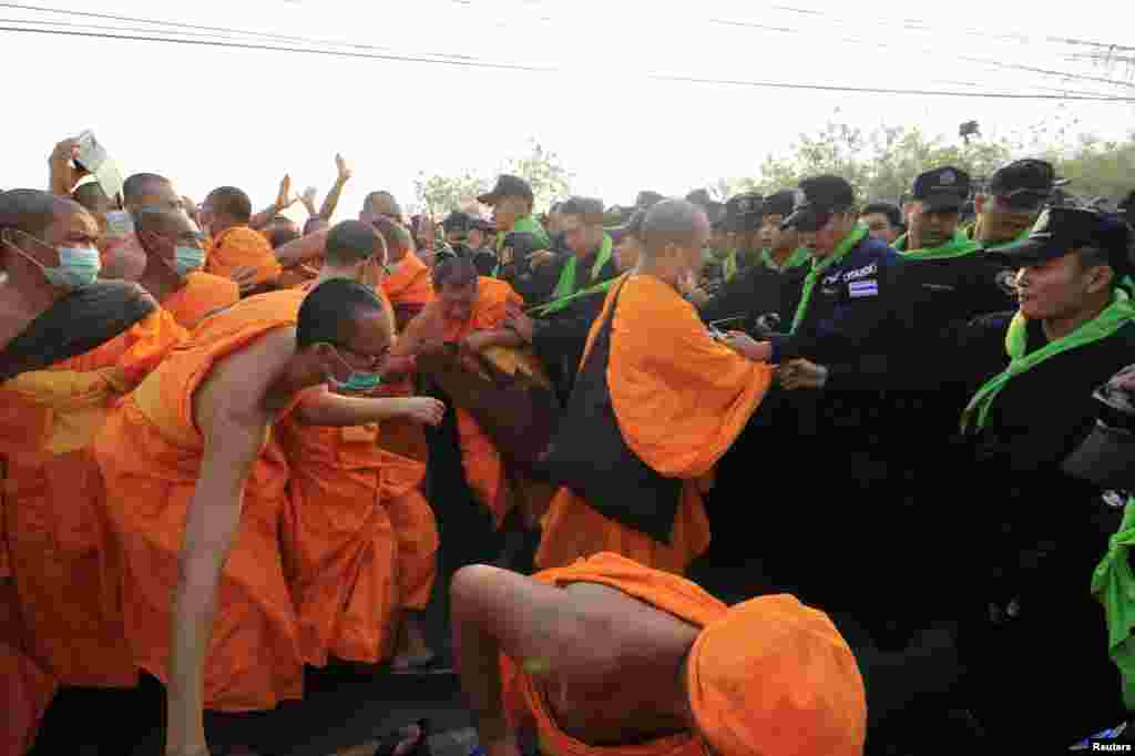Dhammakaya temple Buddhist monks scuffle with police after they defied police orders to leave the temple grounds to enable police to seek out their former abbot in Pathum Thani, Thailand.