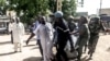 FILE - Security forces transport with a blanket the remains of some of the 11 victims of a double blast in the northern Cameroonian city of Maroua, July 22, 2015. 