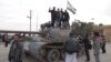 Free Syrian Army fighters pose on a tank after they said they fought and defeated government troops from the town of Ras al-Ain, near the province of Hasaka, 600 kilometers from Damascus, November 22, 2012.