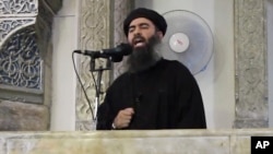 FILE - This image from video posted in July purports to show Islamic State leader Abu Bakr al-Baghdadi delivering a sermon in Iraq, July 5, 2014. Islamic State media has announced the death of the leader's son.