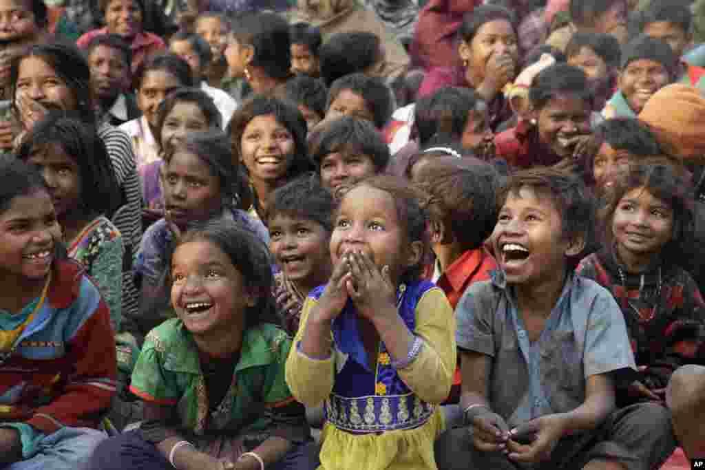 Impoverished Indian children watch a performance as part of advocacy against child labor in Allahabad.