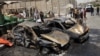 People inspect the aftermath of a car bomb attack in Sadr City, Baghdad, Iraq, July 23, 2012.
