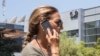 FILE - An woman talks on her iPhone while passing in front of the building housing the Israeli NSO group, maker of the Pegasus spyware, in Herzliya, near Tel Aviv, Aug. 28, 2016.
