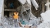 A Red Crescent aid worker inspects scattered medical supplies after an airstrike on a medical depot in the rebel-held Tariq al-Bab neighborhood of Aleppo, Syria, April 30, 2016. 