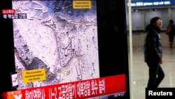 A passenger walks past a television report on North Korea's nuclear test at a railway station in Seoul February 12, 2013.