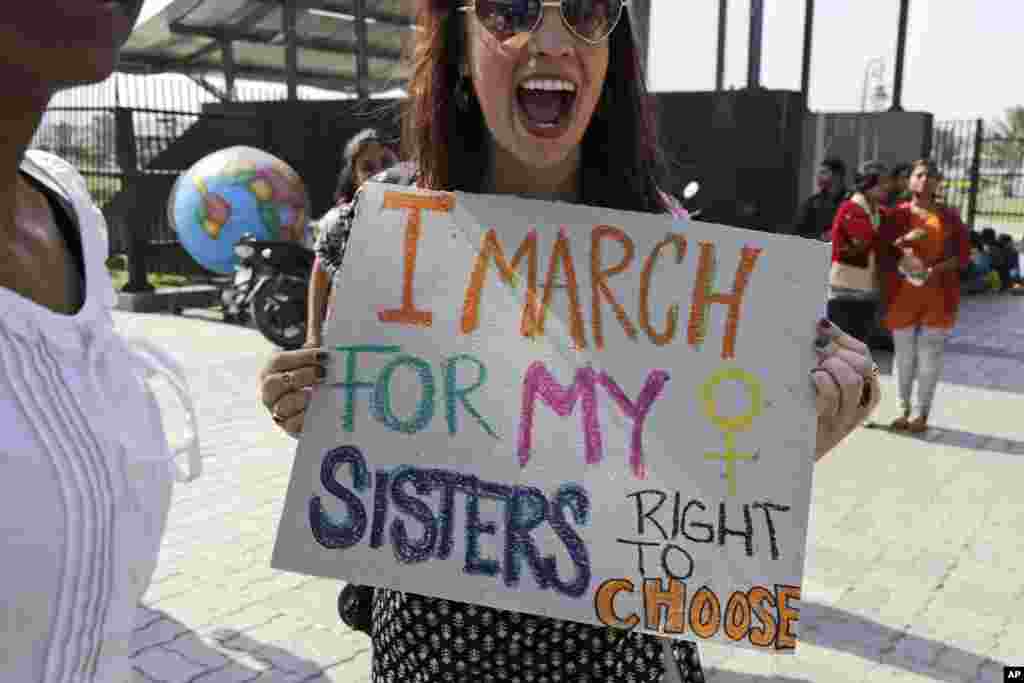 Activist Sarah Annay Williamson holds a placard and shouts slogan during the Women's March rally in Kolkata, India, Jan. 21, 2017.