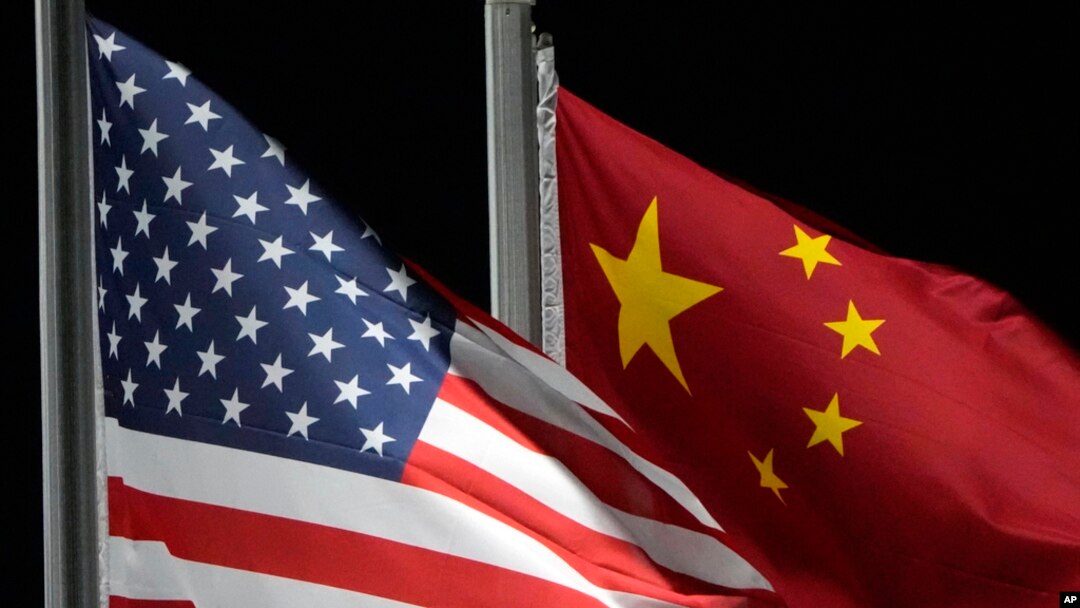 FILE - The American and Chinese flags wave at Genting Snow Park ahead of the 2022 Winter Olympics, in Zhangjiakou, Feb. 2, 2022. The Chinese government placed sanctions on seven companies on Friday in response to recent US announcements of military sales and aid to Taiwan