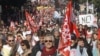 Demonstrators march during a rally with banners and flags to protest against the austerity measures announced by the French government, in Paris, Sunday, Sept 30, 2012.