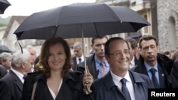 France's President Francois Hollande, right, and his companion Valerie Trierweiler take part in a march as part of a ceremony in tribute to the memory of Nazi victims in Tulle, southwestern France, June 9, 2012.