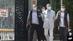 Hong Kong media tycoon Jimmy Lai, center, who founded local newspaper Apple Daily, is arrested by police officers at his home in Hong Kong, Aug. 10, 2020.