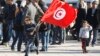 A Tunisian boy waves a flag as he runs during a rally to mark the third anniversary of the Tunisian revolution, in Tunis, Tunisia, Dec. 17, 2013.