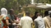Nigerian President Goodluck Jonathan (C) and "ThisDay" newspaper owner Nduka Obaigbena (L) visit the site of an April 26 suicide attack which struck the newspaper's offices, in Abuja, on April 28, 2012.