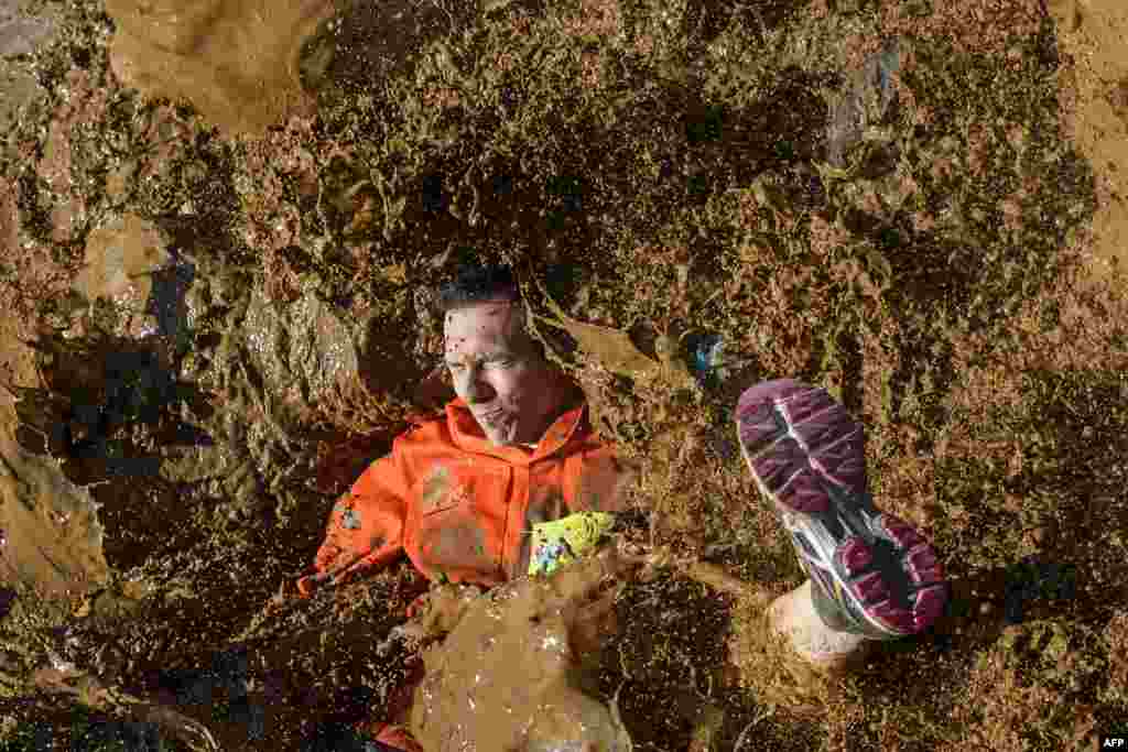 A competitor lands in mud in the "Barjot Run" obstacle race in Biere, western Switzerland, April 8, 2017.
