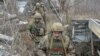 FILE - Service members of the Ukrainian armed forces walk on the line of separation from pro-Russian rebels near Donetsk, Ukraine, April 11, 2021.