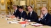 French President Francois Hollande, flanked by his Interior Minister Bernard Cazeneuve, right, and Prime Minister Manuel Valls, 2nd left, looks on during a meeting with French representatives of the different religion at the Elysee Palace in Paris, Wednes