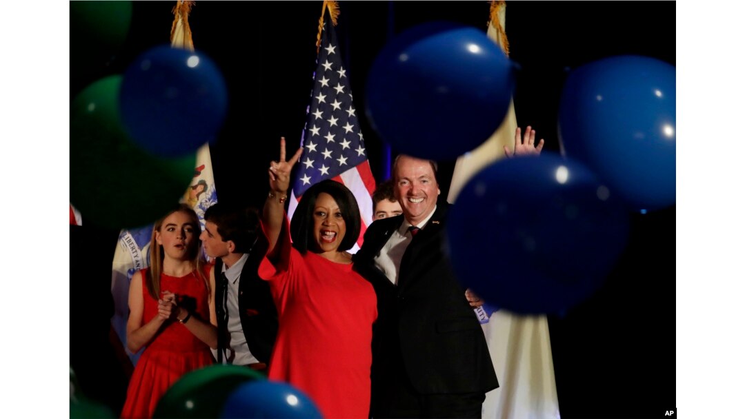 New Jersey gubernatorial nominee Phil Murphy, right, and Lt. Gov. nominee Sheila Oliver wave to supporters as balloons drop during their election night victory party at the Asbury Park Convention Hall, Nov. 7, 2017, in Asbury Park, New Jersey.