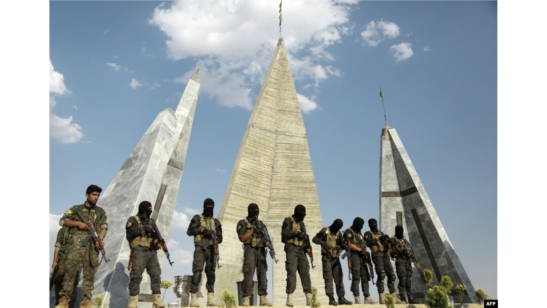 FILE - Members of Syrian Democratic Forces (SDF) attend the funeral of eight fellow fighters who died during an assault against the Islamic State (IS) group in the town of Manbij, in the Syrian Kurdish town of Kobane (aka Ain al-Arab) on June 24, 2016.