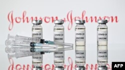 FILE - This illustration photo taken Nov. 17, 2020, shows vials with COVID-19 vaccine stickers attached and syringes with the logo of US pharmaceutical company Johnson & Johnson. 