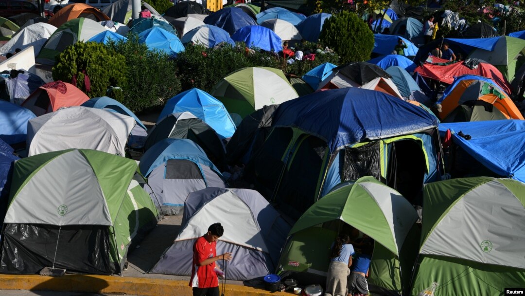 FILE - Migrants, most of them asylum-seekers sent back to Mexico from the U.S. under the "Remain in Mexico" program, officially named Migrant Protection Protocols (MPP), occupy a makeshift encampment in Matamoros, Tamaulipas, Mexico, Oct. 28, 2019.