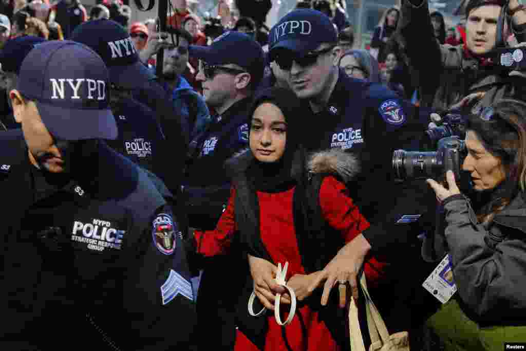 New York Police Department officers arrest a woman who is taking part in a 'Day Without a Woman' march on International Women's Day in New York, March 8, 2017.