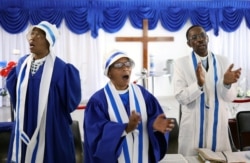 FILE - Faithful worship during a church service amid concerns about the spread of coronavirus disease (COVID-19) at the Apostolic Christian Church in Kagiso, west of Johannesburg, South Africa, March 22, 2020.