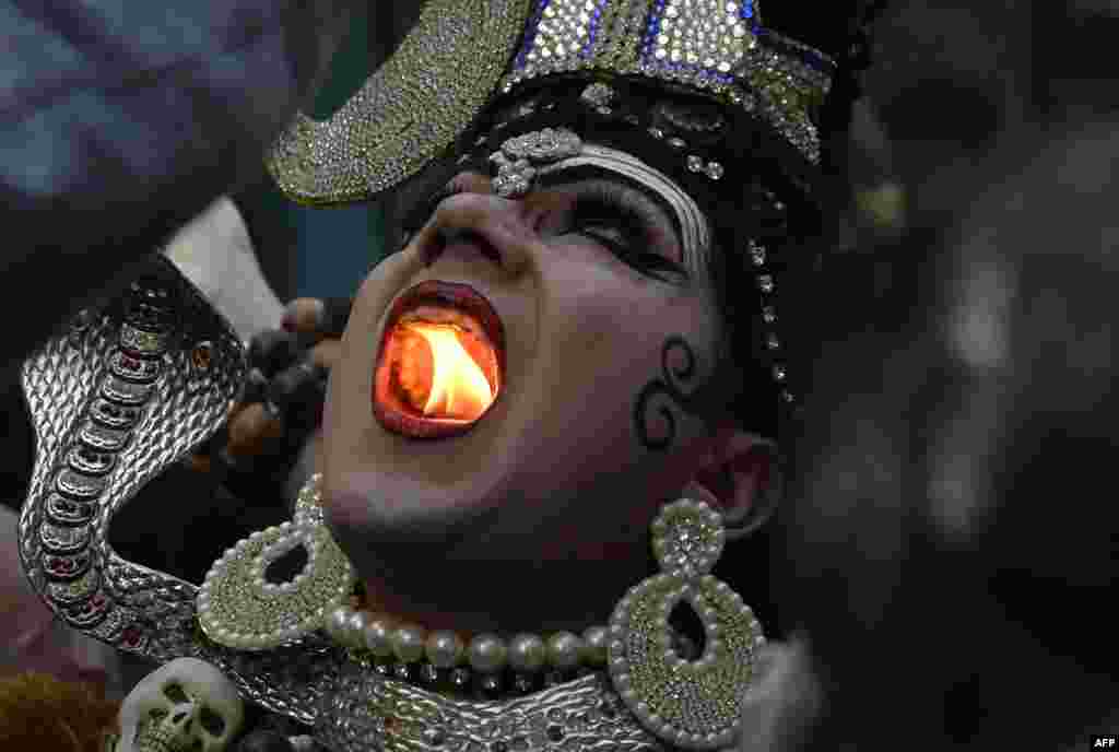 An Indian Hindu man dressed as Lord Shiva holds a lit candle in his mouth in a religious procession ahead of the Maha Shivratri Festival in Jalandhar, Feb. 22, 2017.