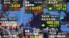 A securities firm's electronic stock indicator reflects pedestrians passing by in Tokyo, June 20, 2016. Global markets jumped Monday as polls suggest British voters on Thursday will choose to remain in the European Union. 