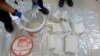 In this undated recent photo provided by the Australian Federal Police, an investigator removes packages of the methamphetamine drug from containers in Sydney. 