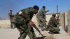 FILE - In this photo taken on Oct. 11, 2015, Syrian soldiers fire repelling an attack in Achan, Hama province, Syria.