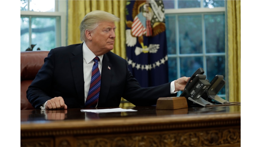President Donald Trump talks on the phone with Mexican President Enrique Pena Nieto, in the Oval Office of the White House, Aug. 27, 2018.