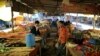 Indian vegetable vendors chat as they wait for customers during lockdown to control the spread of the new coronavirus, on the outskirts of New Delhi, India, Tuesday, April 7, 2020.
