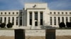 FILE - The U.S. Federal Reserve Board building is shown behind security barriers in Washington.