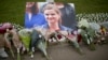 An image and floral tributes for Jo Cox, the 41-year-old British Member of Parliament shot to death yesterday in northern England, lie placed on Parliament Square outside the House of Parliament in London, June 17, 2016. 