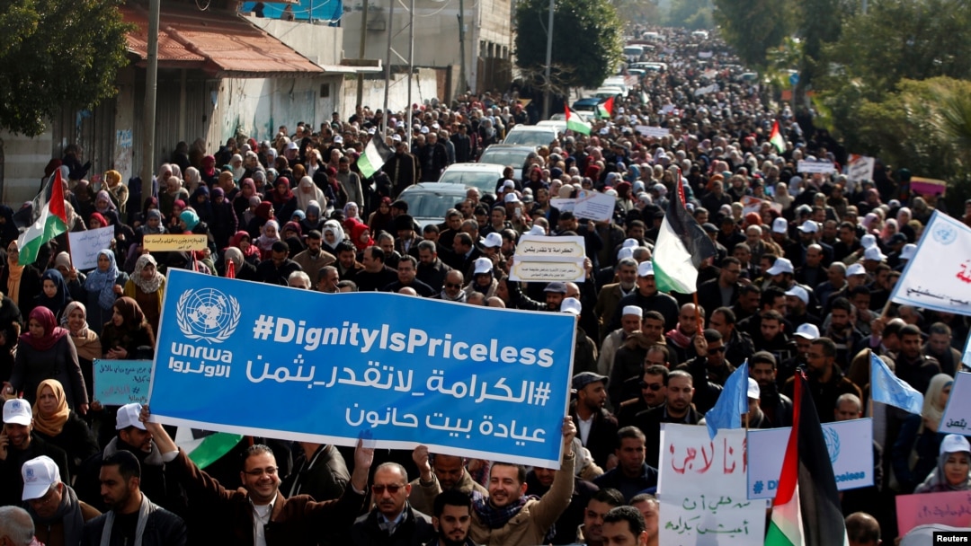 Palestinian employees of the United Nations Relief and Works Agency (UNRWA) hold signs during a protest against a U.S. decision to cut aid, in Gaza City, Jan. 29, 2018. 