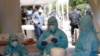 Health workers get ready at a COVID-19 testing center in New Delhi, India, April 27, 2020. India’s main medical research organization has cancelled orders to procure rapid antibody test kits from two Chinese companies. 