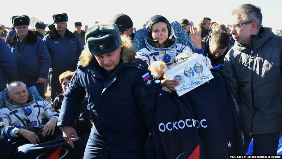 Ground personnel carry the International Space Station (ISS) crew member Russian actor Yulia Peresild after landing in a remote area outside Zhezkazgan, Kazakhstan, Oct. 17, 2021.