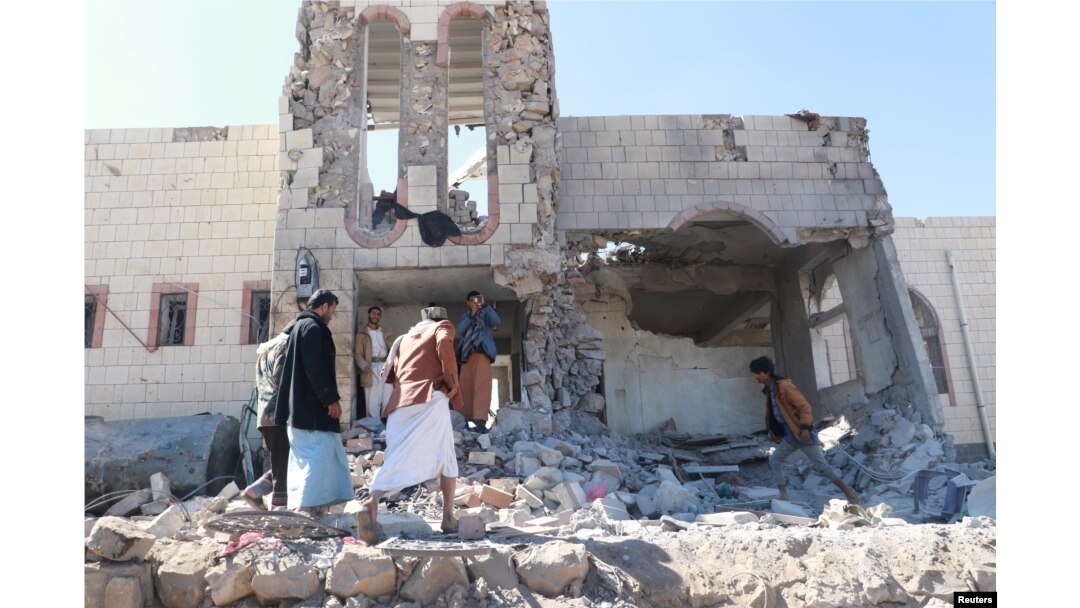 People inspect damage at the site of air strikes in the northwestern city of Saada, Yemen December 20, 2017.