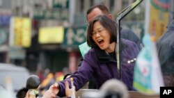 Taiwan's opposition Democratic Progressive Party, DPP, presidential candidate Tsai Ing-wen greets supporters from the back of a truck as she parades through the streets of New Taipei City, Taiwan, Friday, Jan. 15, 2016.